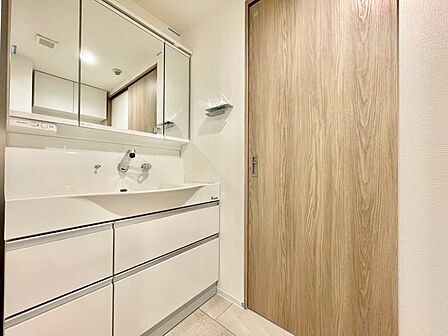 目線に合わせた三面鏡付洗面化粧台を採用しました。三面鏡の裏側には収納棚を確保。スキンケア用品やヘアケア用品などをすっきり整理できます。また収納棚を多く設けており、脱衣スペースを広く確保しております。