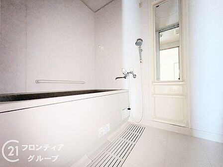 窓から柔らかな自然光が差し込む、開放感あふれるバスルームです。一日の疲れを優雅にリセットし、心身ともにリラックスできる癒やしのひとときを演出します。清潔感のあるカラーリングが爽やかな朝の時間も彩ります