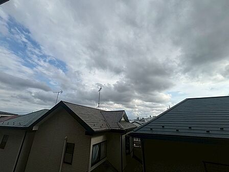 空の広がりを感じながら、落ち着いた住宅街の静かな日常が伝わってくる眺望です。