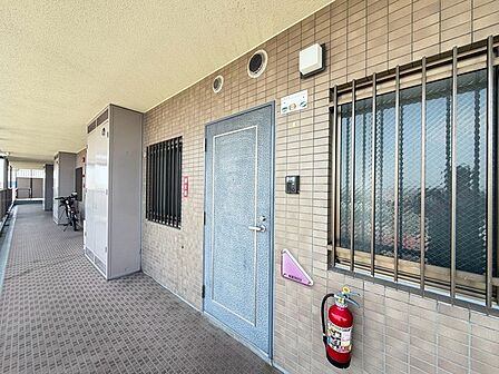 端正なタイル貼りの外壁が続く、日常の風景に溶け込む落ち着いた共用空間です。