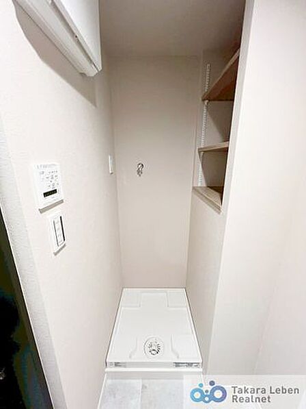 洗面スペースには防水パン付きの洗濯機置場があります。上部の棚は洗剤やタオルなどの収納に便利。