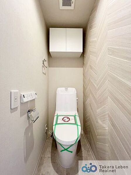 ウォシュレット機能付きのトイレは壁掛けリモコンの上位グレードを採用。便座がスッキリした印象となり、限られた空間を広く見せる効果があります。