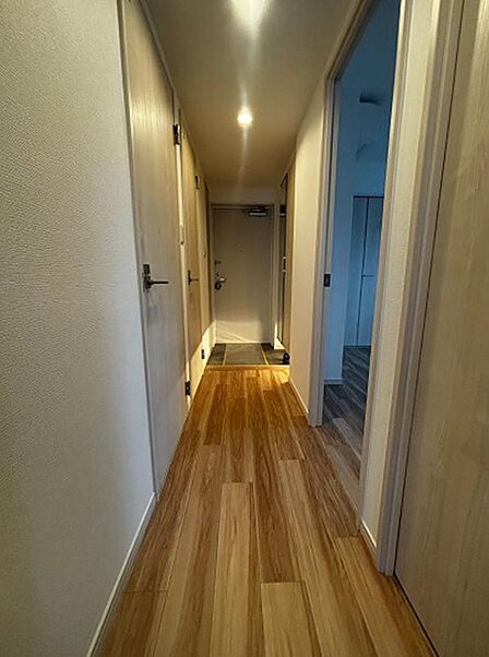 明るい木目調のフローリングが続く廊下。各居室への動線がスムーズで、使いやすい間取りです。居住空間を広々と活用できます。