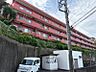 外観：赤が印象的な外観。高台に位置し、開放感があります。駐車場と管理員室があり、日々の暮らしをサポートします。