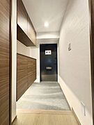 天井まで届く大型収納付きで、生活感を抑えたホテルライクな玄関空間。落ち着いた色合いと直線的なデザインが、洗練された印象の玄関です。