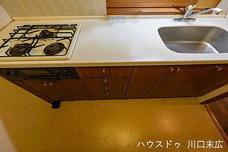 シンクと作業スペースを確保した、機能的なシステムキッチンです。足元には収納キャビネットを備え、調理器具や食器類をすっきりと整理整頓できる実用的な設計です。