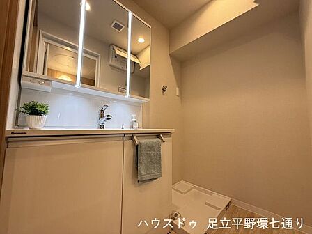 使いやすい三面鏡付きの洗面化粧台と、室内洗濯機置場を備えた清潔な空間です。