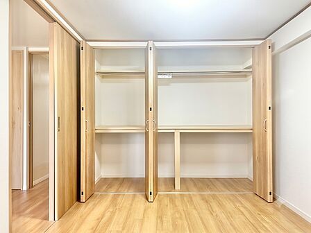 服も布団もスッキリ収まる機能的な壁一面大容量収納!ハンガーパイプと中段棚を備え、衣類から大型荷物まで効率よく整理できます。ナチュラルな木目が心地よい、片付け上手になれる快適居室空間です。