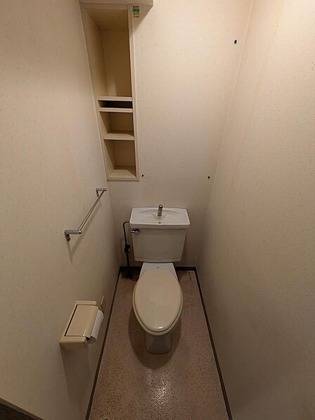 上部棚を備えた清潔感のあるトイレ。トイレットペーパー等のストックにも便利。