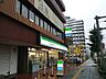 周辺：ファミリーマート北綾瀬駅前店（132m）