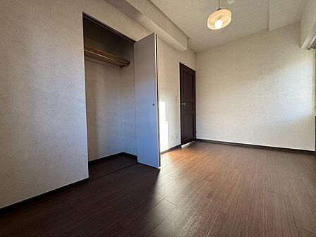 ハンガーパイプと上部の棚を備えたクローゼット。衣類を掛けてしまえ、棚にはバッグや収納箱を置けます。足元の空間も活用すれば、持ち物に合わせた整理ができます。使う場所に収納がある、片付けやすいお部屋です。