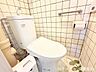 トイレ：壁面にしっかりとした手すりが設置された、安全性に配慮されたトイレスペース。ペーパーホルダー上部には小物を置ける便利な棚もあり、快適に使用できます。