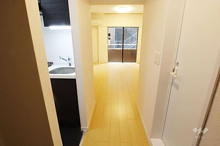 洋室から真っすぐ続く廊下で、南西側バルコニーからの光が玄関まで届きます。とても明るい雰囲気ですね。