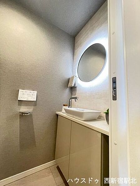 間接照明付きの丸型ミラーがおしゃれな手洗いスペース。
