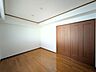 洋室：温もりを感じるフローリングと落ち着いた扉デザインです。大きな収納付きで居住スペースを広く使えます。