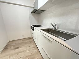 【キッチン】白を基調とした清潔感のあるシステムキッチン。シンクやガスコンロ、レンジフードを完備