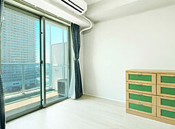 バルコニーに面した明るい洋室。シンプルモダンで統一された室内、生活感を感じさせないスマートライフを。