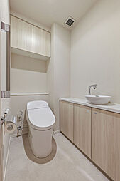 独立した手洗い器が備わった、スタイリッシュなトイレ。吊戸棚にトイレットペーパーなどを収納できます。【トイレ】