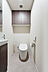 トイレ：吊戸棚や手洗い場・鏡つきのトイレ空間です。