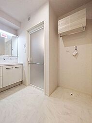 【脱衣場】引き出しタイプの洗面収納、洗濯機置き場上部にはキャビネットタイプの収納。