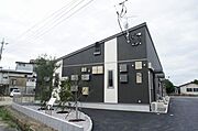 黒い外壁に白いストライプがアクセントの外観です