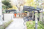 居住者専用の屋根付き自転車置場です。庭園灯に導かれ緑の中を通り抜けます。