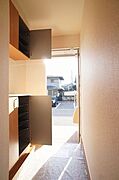 【玄関】上下に分かれたシューズボックスは豊富な収納力。可変式の棚になっているのでブーツもすっきり収納ができます。カウンターに小物などを飾ってギャラリーのような高品位な空間を演出できます。