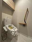 【トイレ】ユニバーサルデザインの手すりがついた暖房洗浄機能付き便座のトイレです