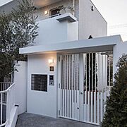 白を基調とした洗練された外観に、アプローチの植栽が優しくお迎え致します