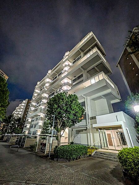 温かみのある光が灯る夜のエントランス。外灯が明るく敷地内を照らし、夜間も安心感のある住環境です。
