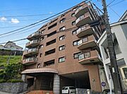 大切なペットと一緒に暮らせるマンション（細則有）。周囲の緑や空の青に映えるブラウン系のタイルが採用されており、落ち着いた気品ある佇まいを演出しています。