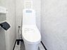 トイレ：壁面に明るいグレーの石目調パネルを採用。これにより、圧迫感を感じさせず、ラグジュアリーで清潔感のある空間を演出しています。