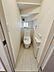 トイレ：手洗い付きのトイレが設置されておりコンパクトながらも空間を有効に活用しています。小窓から自然光が入り換気にも配慮されています。壁面にはペーパーホルダーと収納スペースが確保されています。