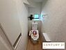 トイレ：白を基調とした清潔感のあるトイレ空間です。温水洗浄便座や手洗いカウンターを備えているほか、小窓からの採光で明るく、サイドには棚付きの収納スペースも設置されています。