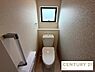 トイレ：小窓から自然光が差し込む、明るく清潔なトイレ空間です。アクセントクロスが洗練された印象を与え、温水洗浄便座や手すり、ペーパーホルダー付きの棚など、快適な設備も充実しています。
