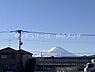 その他：晴れ渡る空の下で山の景色が印象的に広がっています。遠くには有名な山が見え日常に特別な開放感を演出します。周辺は落ち着いた住宅や施設が並び穏やかな雰囲気となっています。
