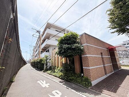 レンガ調の外観が印象的なマンションです。緑が映える植栽が並び清潔感のあるエントランスが整っています。周囲は歩道も整備されており快適なアプローチが可能です。敷地周辺は開放感を感じられる空間設計です。