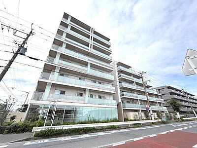 外観：スタイリッシュな外観が目を引くマンションです。ガラスバルコニーが開放感を演出しています。明るいカラーリングが建物全体に清潔感をプラスしています。ゆとりのあるエントランス周りも印象的です。