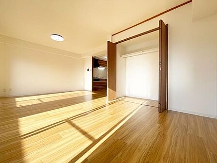 大きな窓からたっぷり光が入る開放感のあるリビングです。床の色合いが明るく空間全体がすっきりとした印象です。収納スペースも備わっており室内を広く使うことができます。