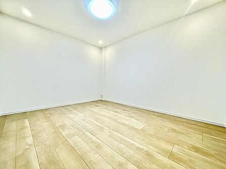 明るいフローリングが特徴的な子供部屋です。シンプルな設計で家具のレイアウトがしやすい空間となっています。天井照明付きで室内が均一に照らされています。壁と床のコントラストがすっきりとした印象を与えます。