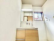 明るい洗面所はナチュラルな木目調の収納が清潔感を引き立てています。大きな鏡付きの洗面台で身支度も快適です。窓があり自然光がしっかり差し込みます。使い勝手の良い広さが魅力です。