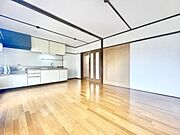 明るいフローリングが広がるリビングです。キッチンが隣接しており使いやすいレイアウトとなっています。大きな扉や収納スペースもしっかり備えています。壁や天井のラインがすっきりした印象を与えます。