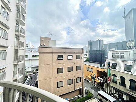 バルコニーからの眺望は周囲に建物が広がる都市的な風景が特徴です。開放感のある空間となっており天候や時間帯によって多様な景色が楽しめます。通りの様子も一望でき利便性を感じられる立地です。