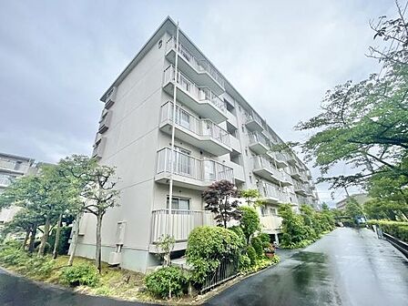 落ち着いた雰囲気の外観が特徴のマンションです。周囲には緑も多く心和む景観が広がります。敷地内には手入れされた植栽があり季節の移ろいを感じられます。すっきりとしたデザインが印象的です。