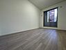 子供部屋：洋室はすっきりとしたシンプルな内装が特徴です。ナチュラルな色合いのフローリングが空間を広く見せます。大きな窓からは光が取り込め明るい印象を持たせます。壁面は家具の配置がしやすい設計です。