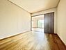 寝室：落ち着いた色味のフローリングが特徴の寝室です。スライドドアで空間を仕切ることができ使い勝手の良い造りです。隣室との一体感があるレイアウトで広がりを感じられます。開口部から自然光が入る寝室です。