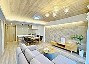 洗練された木目調の天井とアクセントウォールが印象的なLDK。対面キッチンで家族の会話が弾み、広々としたリビングでゆったりと過ごせます。家具・小物類はディスプレイ用です。