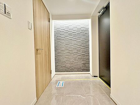 間接照明が優しく灯る、意匠性の高いアクセントウォール。上品な光沢を放つ床のストーンタイルとともに、住まいの格式を高める洗練された意匠が魅力です。