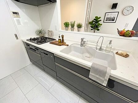 ホームパーティーを催して自慢したくなるオシャレな空間のキッチン。この雰囲気に合わせる家具や家電探しはワクワクばかり。食器洗い乾燥機付きシステムキッチン。※AIにより家具・小物等を配置しています。