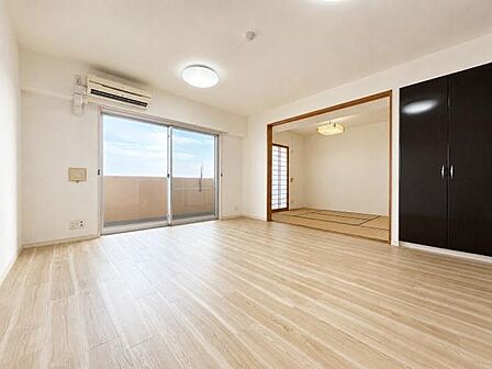 バルコニーから光が差し込む、明るく開放的なリビング。隣接する和室は扉を開けて一体利用でき、くつろぎやお子様の遊び場、来客用など多彩に活用できます。収納も備え、すっきり暮らせます。